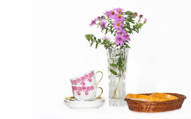 autumn flowers in a vase, two cups and bread