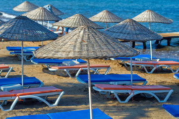 Beach wicker umbrellas on the coast of the Aegean Sea of Turkey.