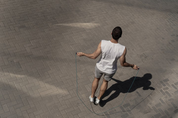 Young male athlete skipping rope outdoors