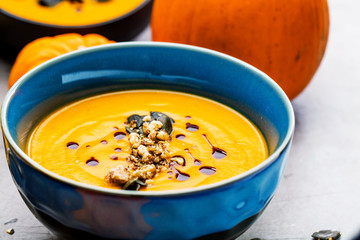 Roasted pumpkin and carrot soup with cream and pumpkin seeds 