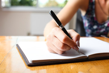 Woman writes in notebook