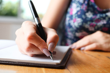 Woman writes in notebook