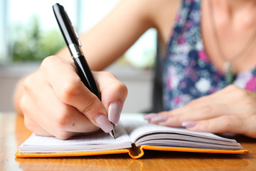 Woman writes in notebook