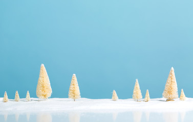 Small green and white Christmas trees in snow