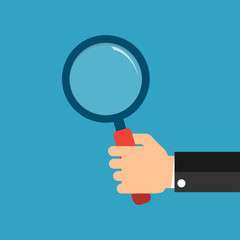 Hands with magnifying glass.