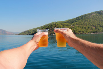 Two friends say a toast to the sea. The concept of friendship.