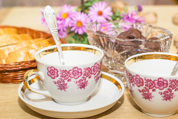 white bread and two teacups on a wooden table