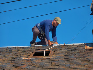 Maintenance of the roof of an old village house with slate tiles.