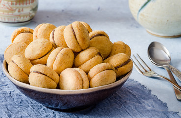 'Baci di dama': delicious chocolate cookies with hazelnuts and topping on delecate background