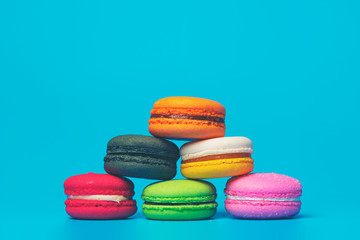 Cake macaron or macaroon on turquoise background from above, colorful almond cookies, pastel colors, vintage card