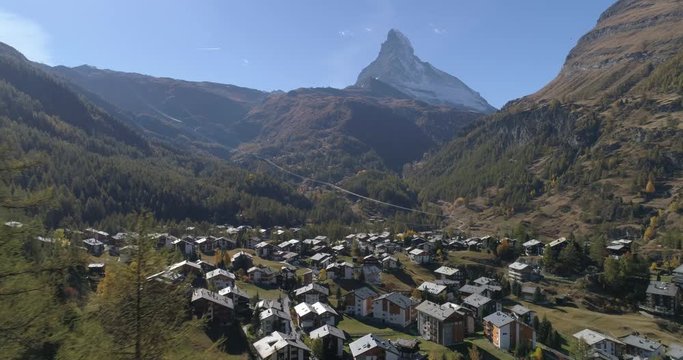 Zermatt village appearing between trees - Aerial 4K