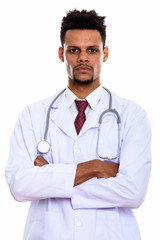 Studio shot of young African man doctor with arms crossed