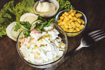 salad of sweet corn, crab sticks and mayonnaise. on wooden background.