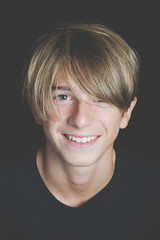Fototapeta premium Young handsome guy headshot - concept of happy freedom lifestyle - smiling boy on dark mood filtered look