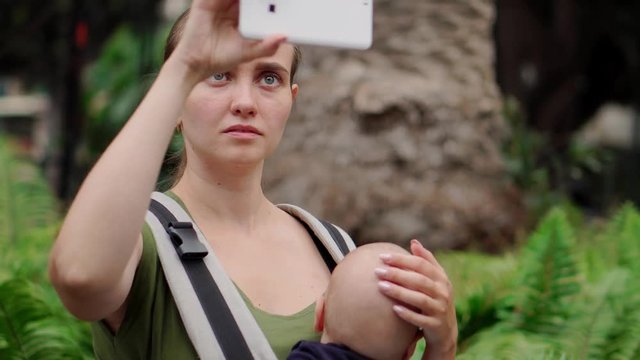 A woman with a baby travels in Europe and takes sight on a mobile phone