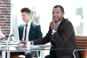 young businessman sitting behind a Desk in a modern office.