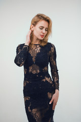 Pretty blonde woman posing isolated on white background. Studio shot of attractive female with middle length blonde hair wearing dress with lace detail.