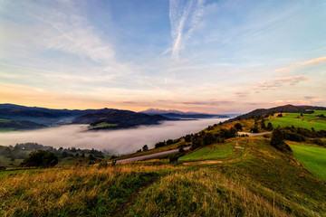 Beautiful sunrise over high rocky peaks and misty and foggy valley in High Tatras mountains on Slovak and Polish border.