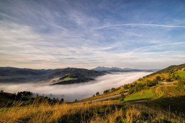 Beautiful sunrise over high rocky peaks and misty and foggy valley in High Tatras mountains on Slovak and Polish border.