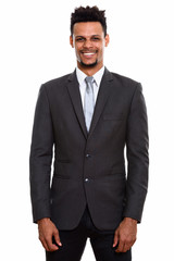 Studio shot of young  happy African businessman smiling while st
