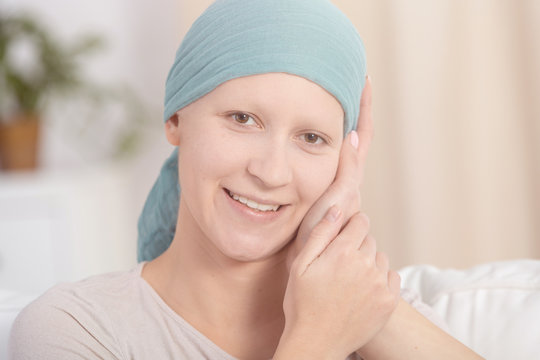 Woman with cancer smiling and being touched by someone