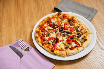 pizza in a white plate on a wooden table
