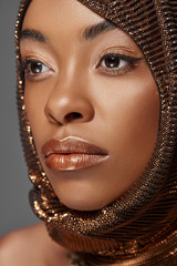 portrait of pensive african american model with head wrap looking away isolated on grey
