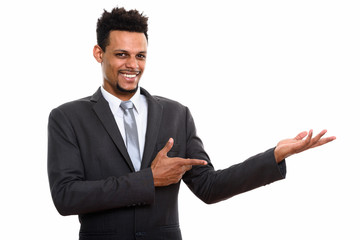 Studio shot of young happy African businessman smiling while sho