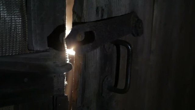 Rays of light through the slits of the door.