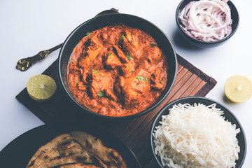 Murgh Makhani / Butter chicken tikka masala served with roti / Paratha and plain rice along with onion salad. selective focus