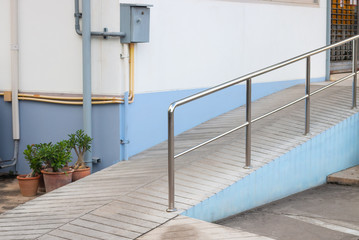 Ramp way with stainless steel handrail for support wheelchair disabled people infront of the building