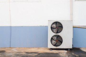 Old air conditioner compressor installed in beside building