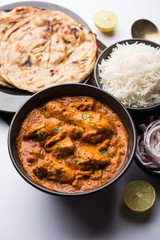 Murgh Makhani / Butter chicken tikka masala served with roti / Paratha and plain rice along with onion salad. selective focus