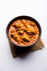 Murgh Makhani / Butter chicken tikka masala served with roti / Paratha and plain rice along with onion salad. selective focus