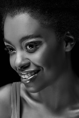 black and white photo of beautiful smiling african american woman isolated on black