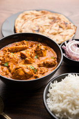 Murgh Makhani / Butter chicken tikka masala served with roti / Paratha and plain rice along with onion salad. selective focus