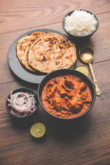 Murgh Makhani / Butter chicken tikka masala served with roti / Paratha and plain rice along with onion salad. selective focus