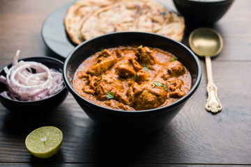Murgh Makhani / Butter chicken tikka masala served with roti / Paratha and plain rice along with onion salad. selective focus