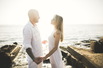 Fototapeta premium Fashion model couple with tattoo posing outside nea sea