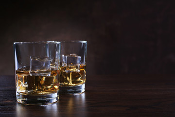 Glasses with whiskey and ice cubes