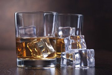 Glasses with whiskey and ice cubes
