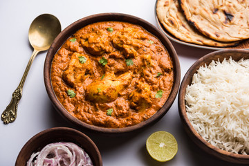 Murgh Makhani / Butter chicken tikka masala served with roti / Paratha and plain rice along with onion salad. selective focus