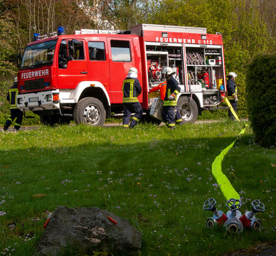 L&ouml;schfahrzeug der Feuerwehr mit Feuerwehrleuten beim L&ouml;schangriff