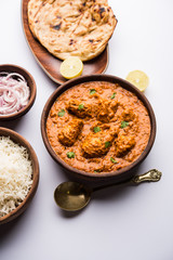 Murgh Makhani / Butter chicken tikka masala served with roti / Paratha and plain rice along with onion salad. selective focus