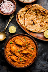 Murgh Makhani / Butter chicken tikka masala served with roti / Paratha and plain rice along with onion salad. selective focus