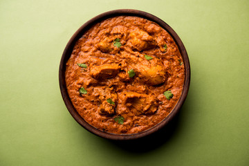 Murgh Makhani / Butter chicken tikka masala served with roti / Paratha and plain rice along with onion salad. selective focus