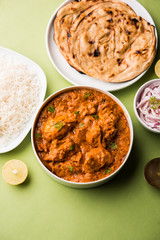 Murgh Makhani / Butter chicken tikka masala served with roti / Paratha and plain rice along with onion salad. selective focus