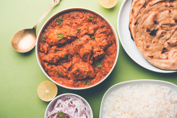 Murgh Makhani / Butter chicken tikka masala served with roti / Paratha and plain rice along with onion salad. selective focus