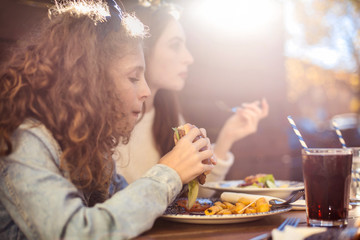 Mother and daughter eating burgers © merla