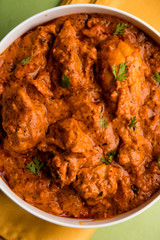 Murgh Makhani / Butter chicken tikka masala served with roti / Paratha and plain rice along with onion salad. selective focus